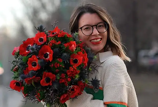 Женщина с букетом красных цветов на улице